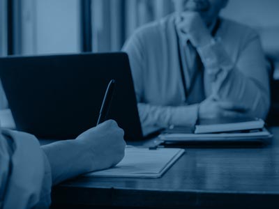 Man and woman at desk in front of laptop